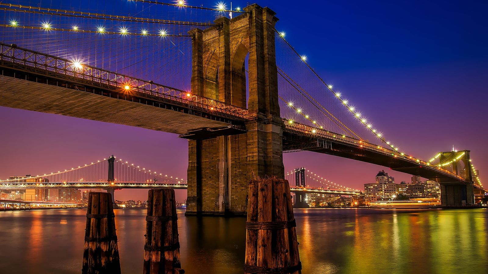 The Brooklyn Bridge stretching across the East River at sunrise, New York City
