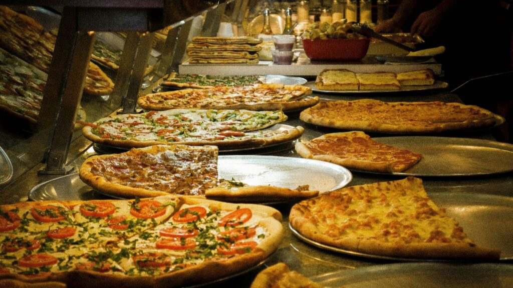 Classic New York style pizzas on trays in a traditional NYC pizzeria