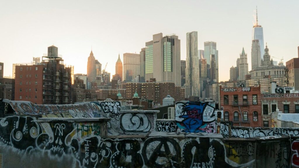 New York City skyline at sunset with graffiti art in the foreground, capturing the spirit of 1970s Bronx urban culture