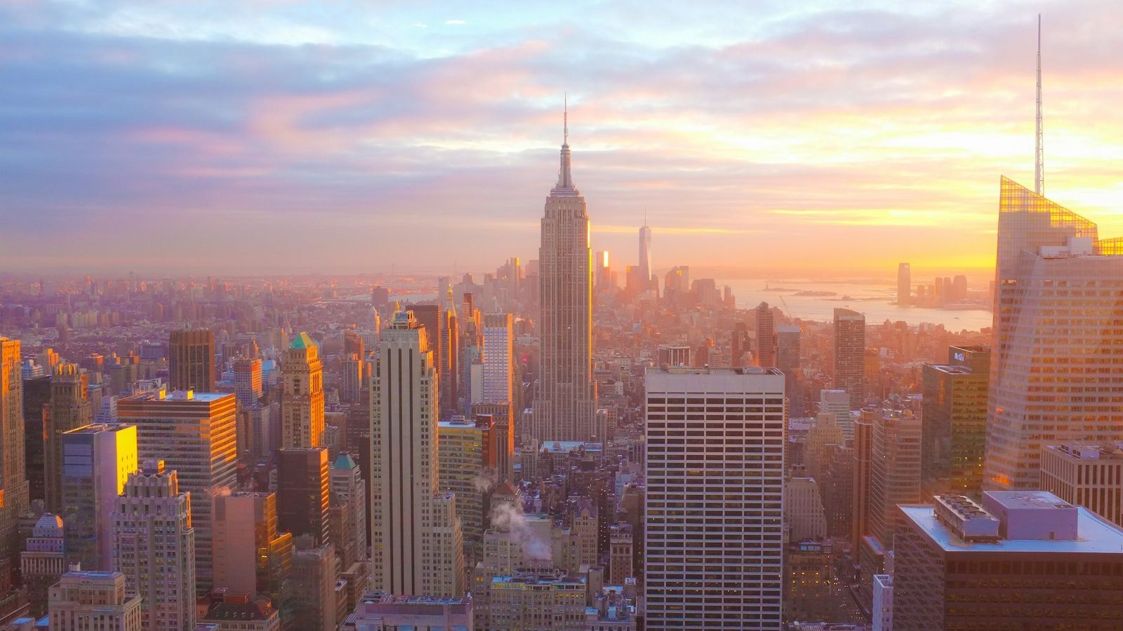 Aerial view of Manhattan rooftop water towers and skyline — the iconic wooden cylinders that have dotted New York City since the 1880s