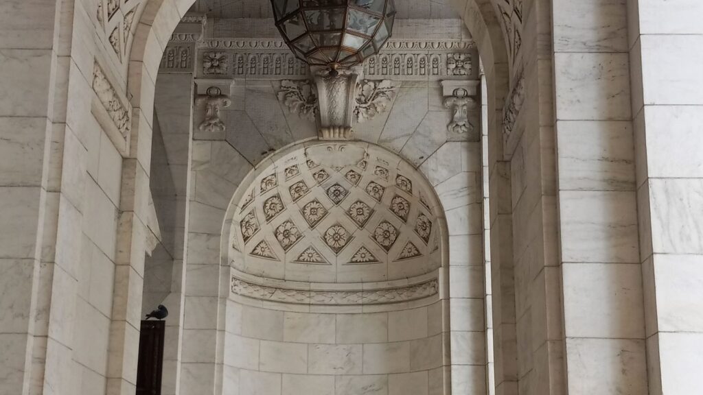 The ornate marble arch and hanging lantern at the entrance of the New York Public Library main branch