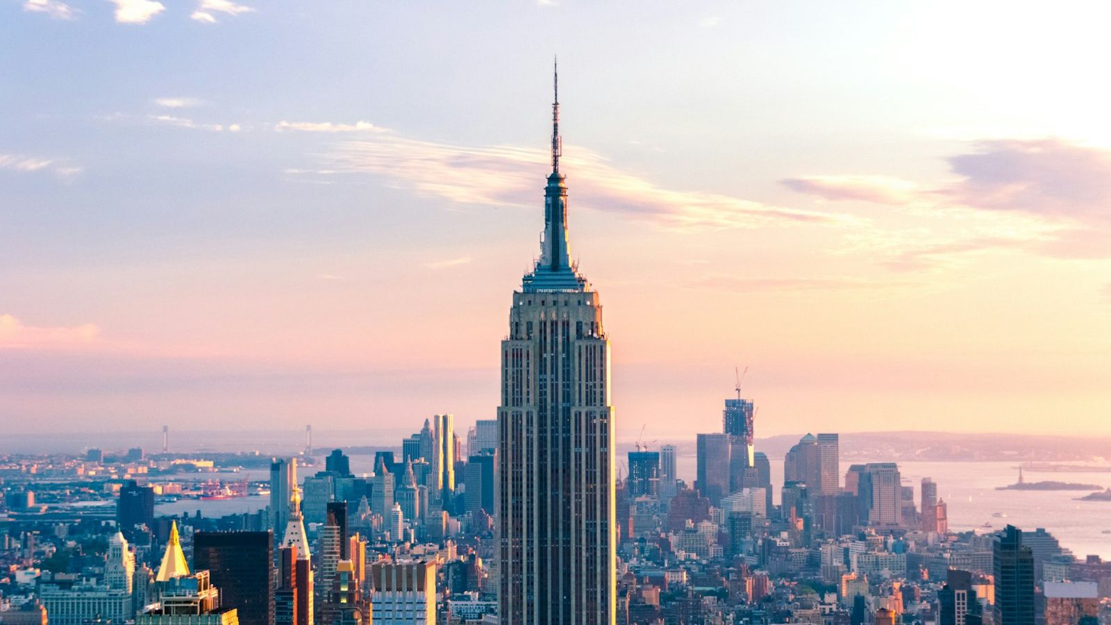The Empire State Building rising above the Manhattan skyline at golden hour, photographed from above
