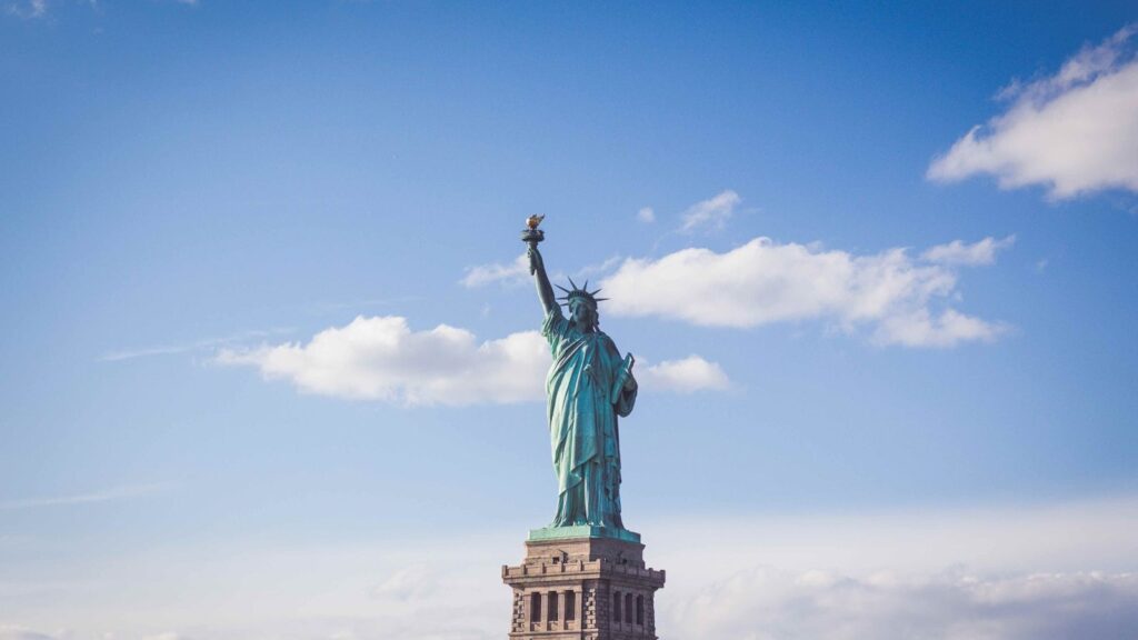 The Statue of Liberty standing against a blue sky, the iconic welcome for millions of Irish immigrants arriving in New York