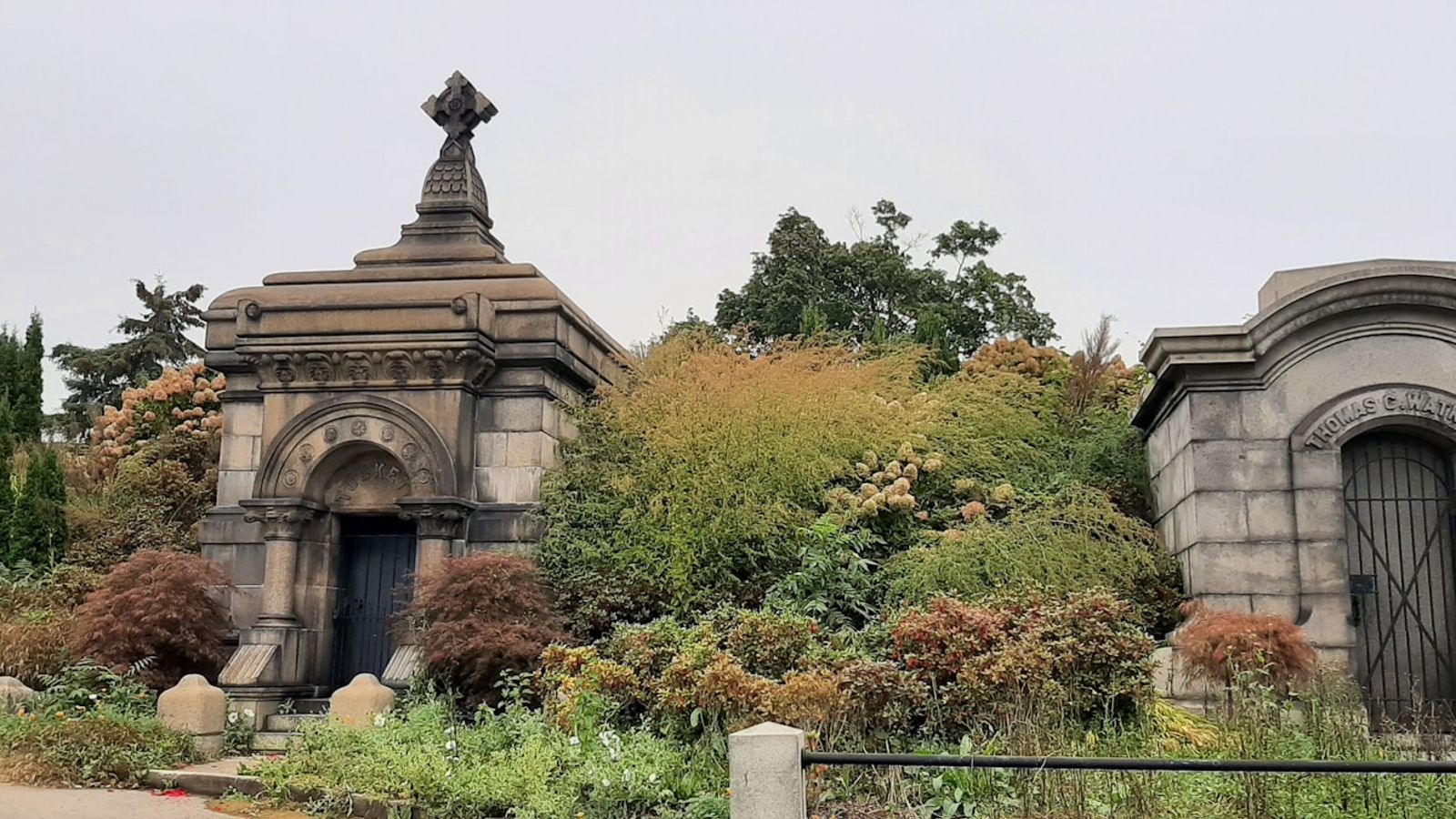 Victorian stone mausoleums surrounded by autumn foliage in a historic cemetery — the kind of landscape that inspired New York's great parks