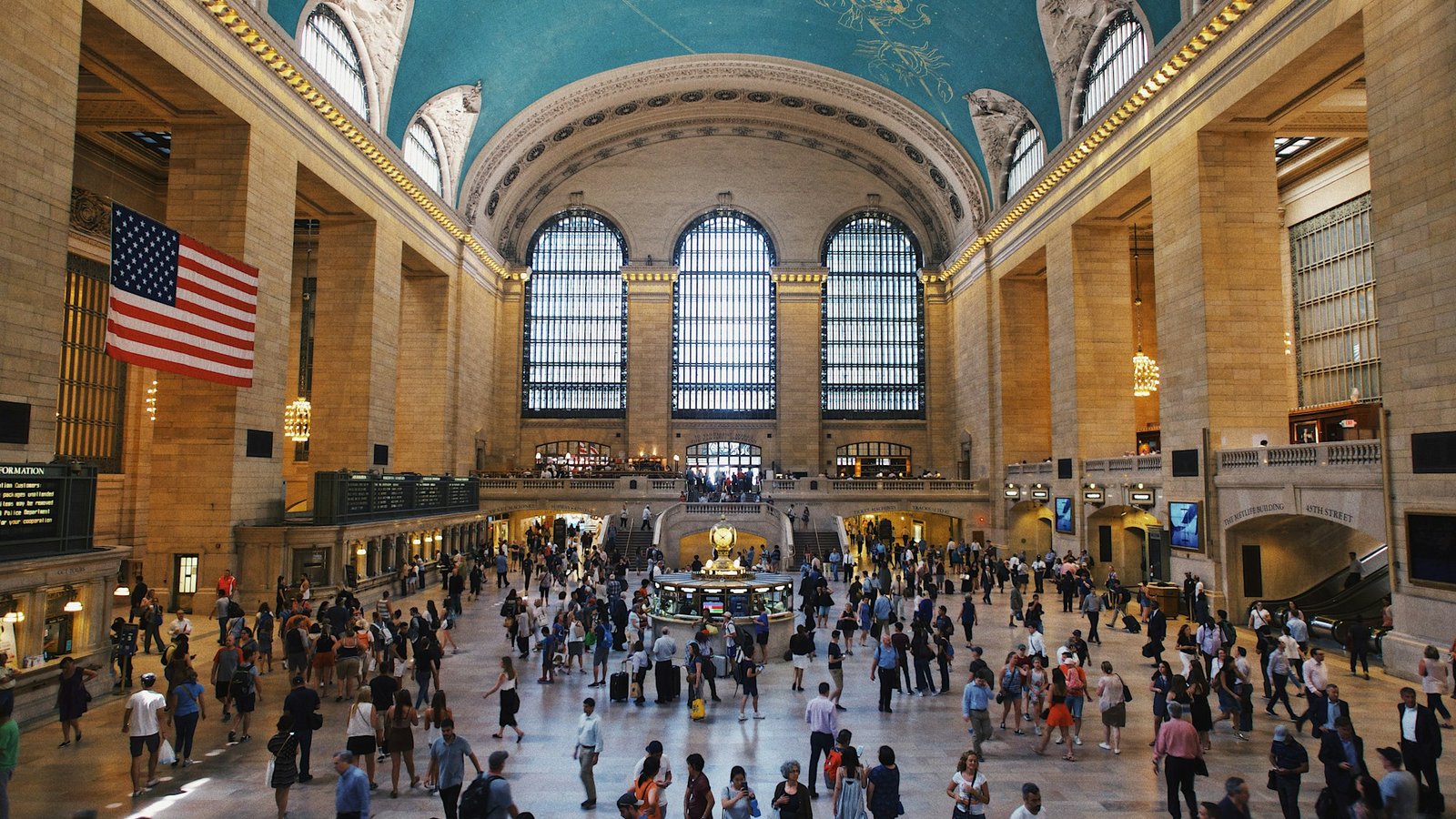 The iconic main concourse of Grand Central Terminal in New York City, showing the vast Beaux-Arts interior with its famous turquoise celestial ceiling and crowds of visitors