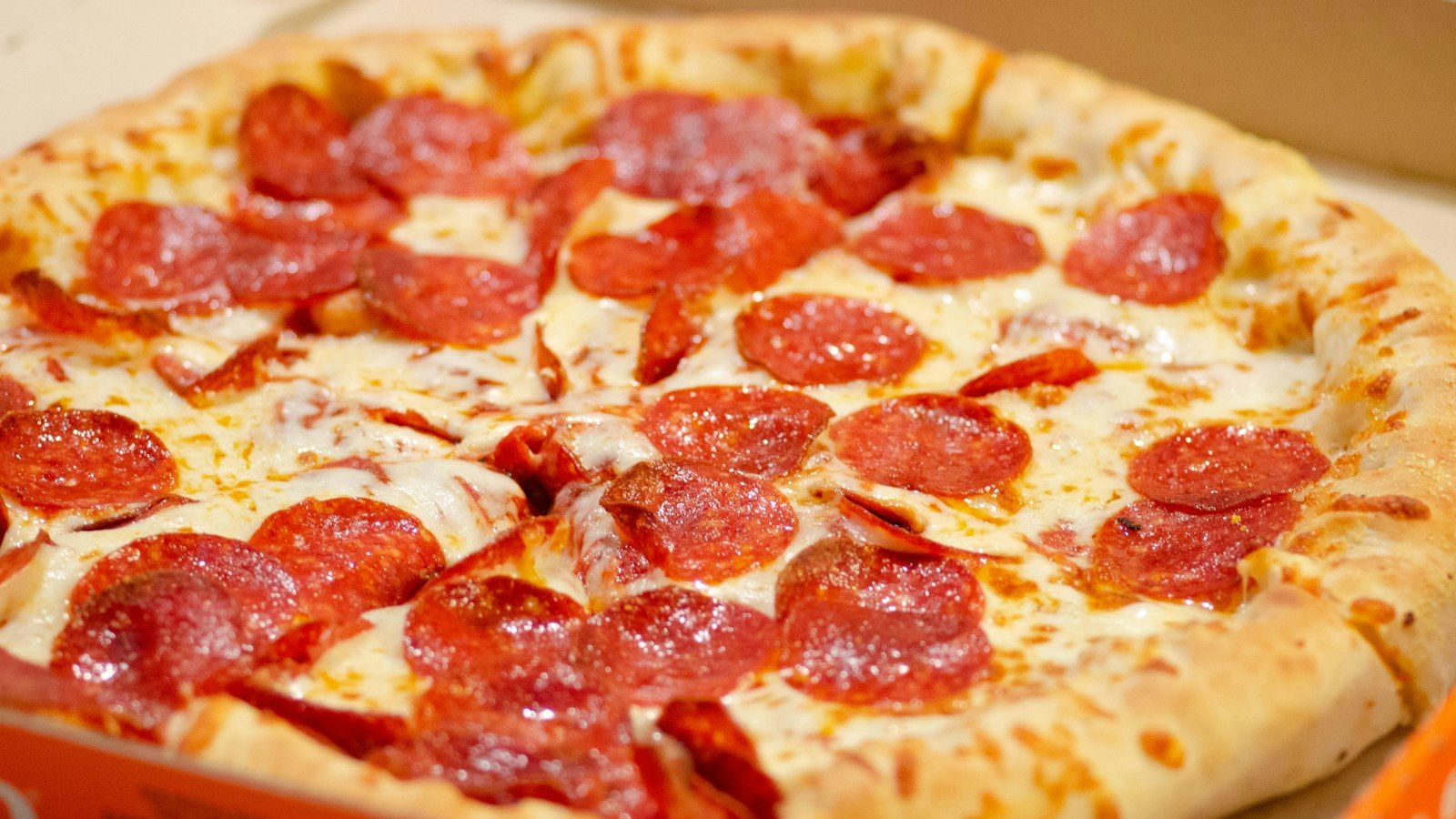 A classic New York pizza slice being served at a NYC pizzeria