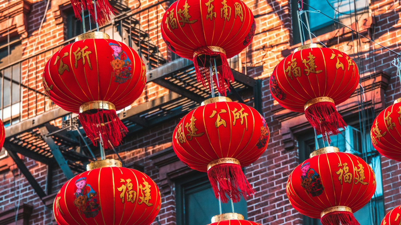 Red Chinese lanterns hanging above the streets of New York City, representing the city's vibrant Asian immigrant communities