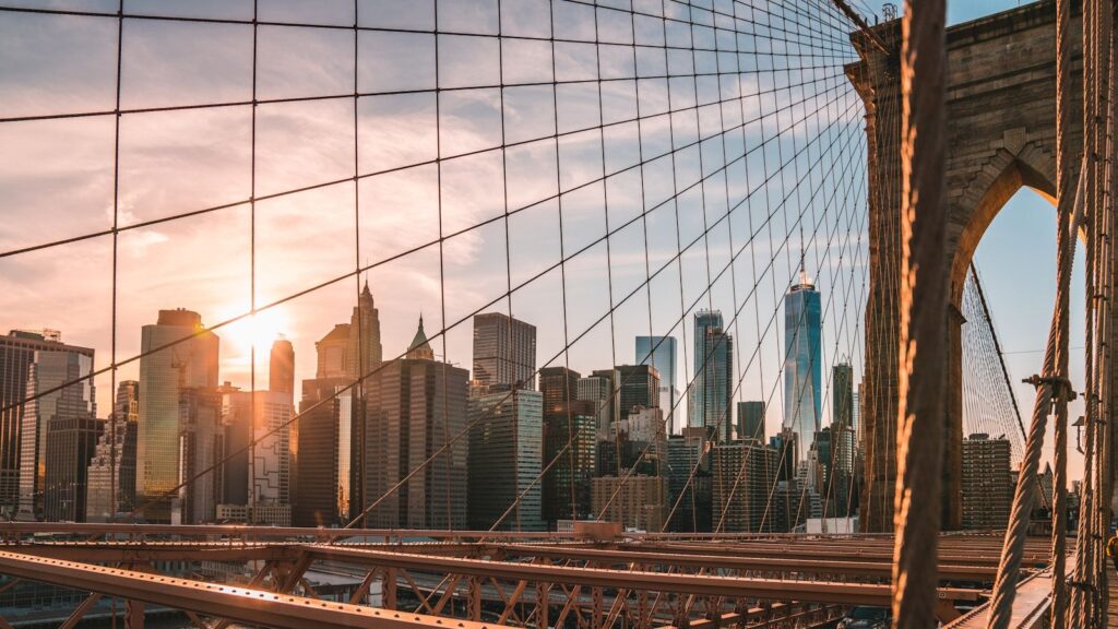 The Manhattan skyline glowing at golden hour, as seen from across the water — the iconic view from the Staten Island Ferry