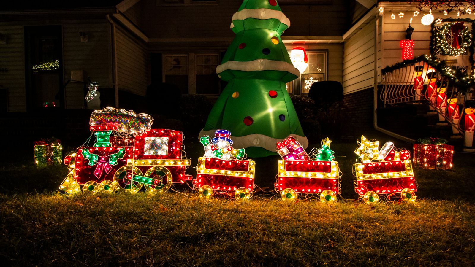 Elaborate Christmas light display with lighted train and inflatable tree in Dyker Heights, Brooklyn