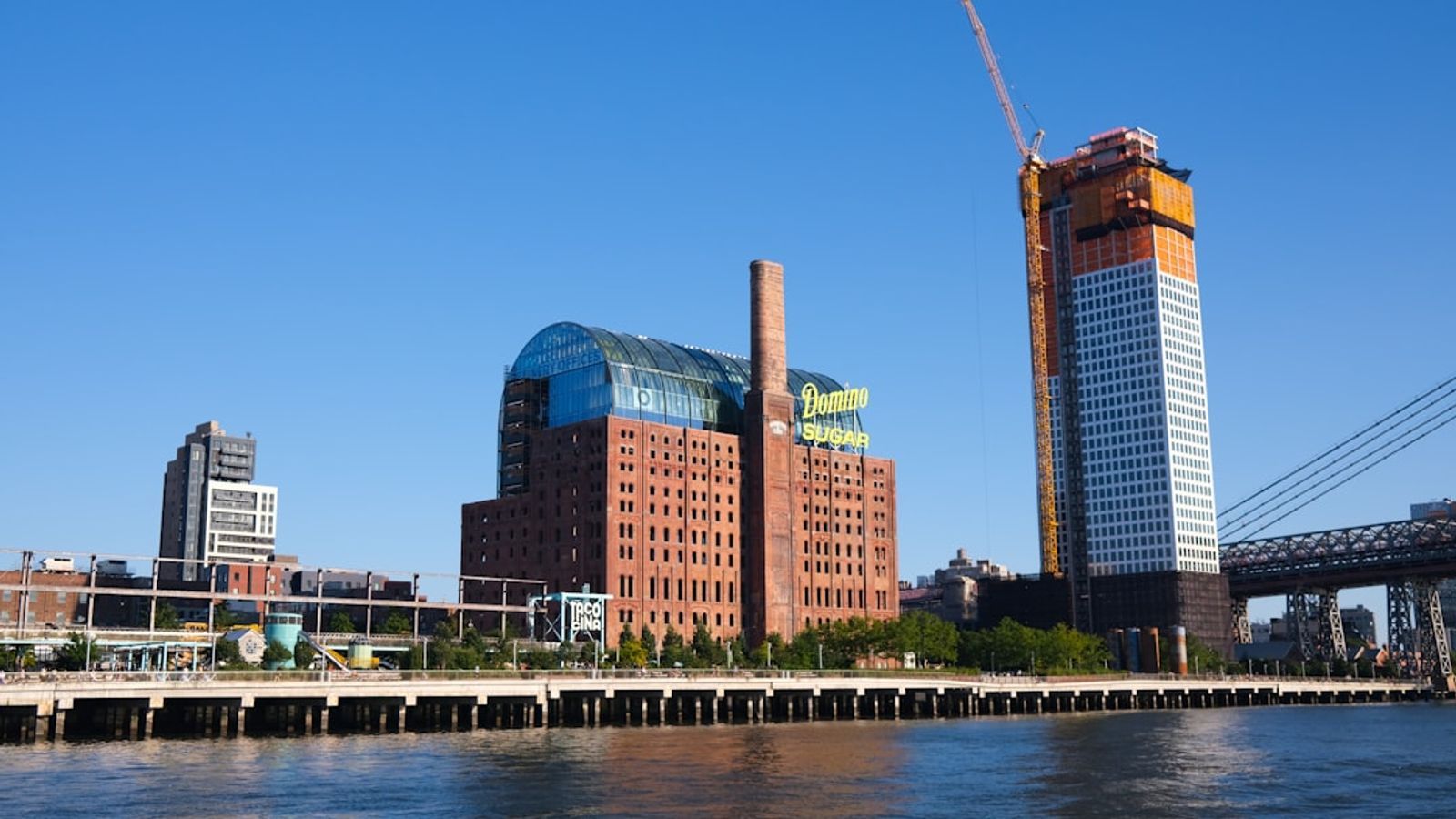 The industrial waterfront along the Brooklyn waterway, with old brick warehouses reflected in the calm canal water