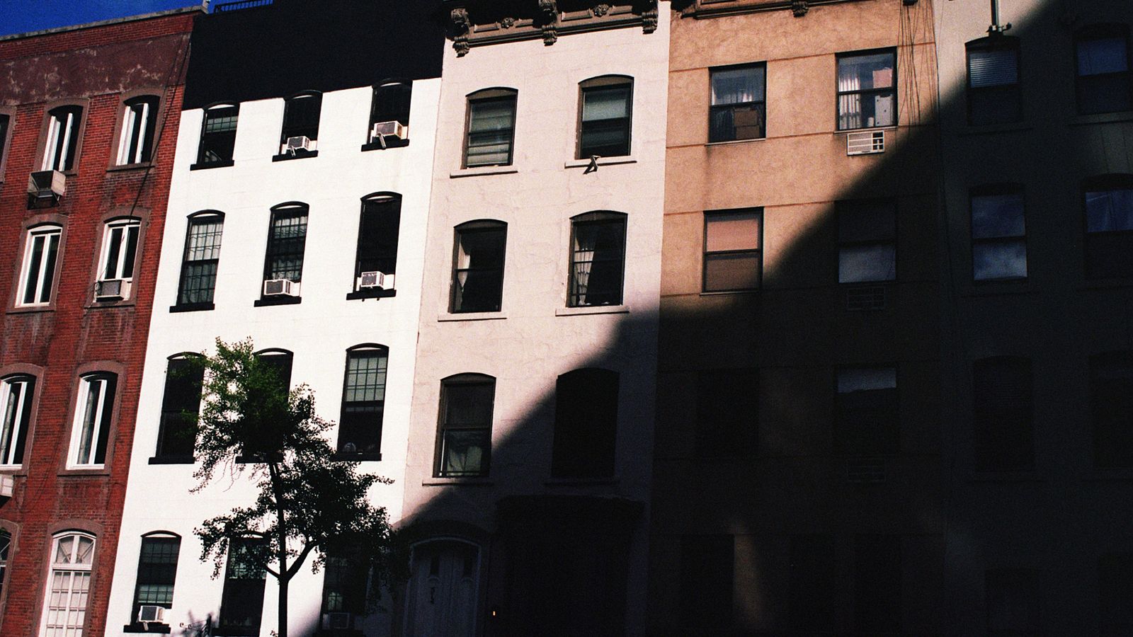 Colorful New York City apartment buildings with fire escapes on a classic NYC neighbourhood street