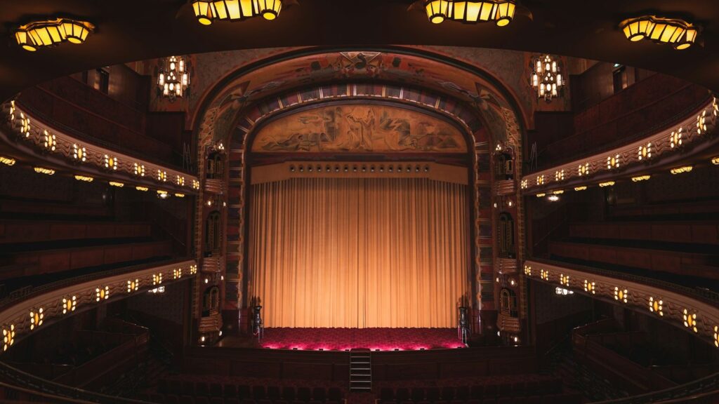 Empty theater stage with dramatic red and amber lighting in a New York City Broadway theater