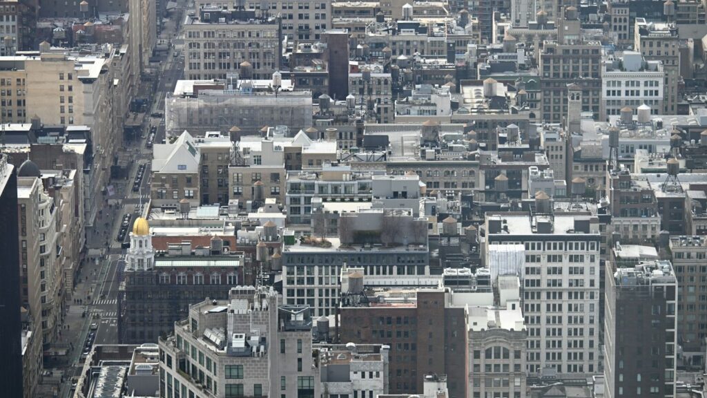 Aerial view of New York City rooftops and buildings from above — the dense Manhattan skyline