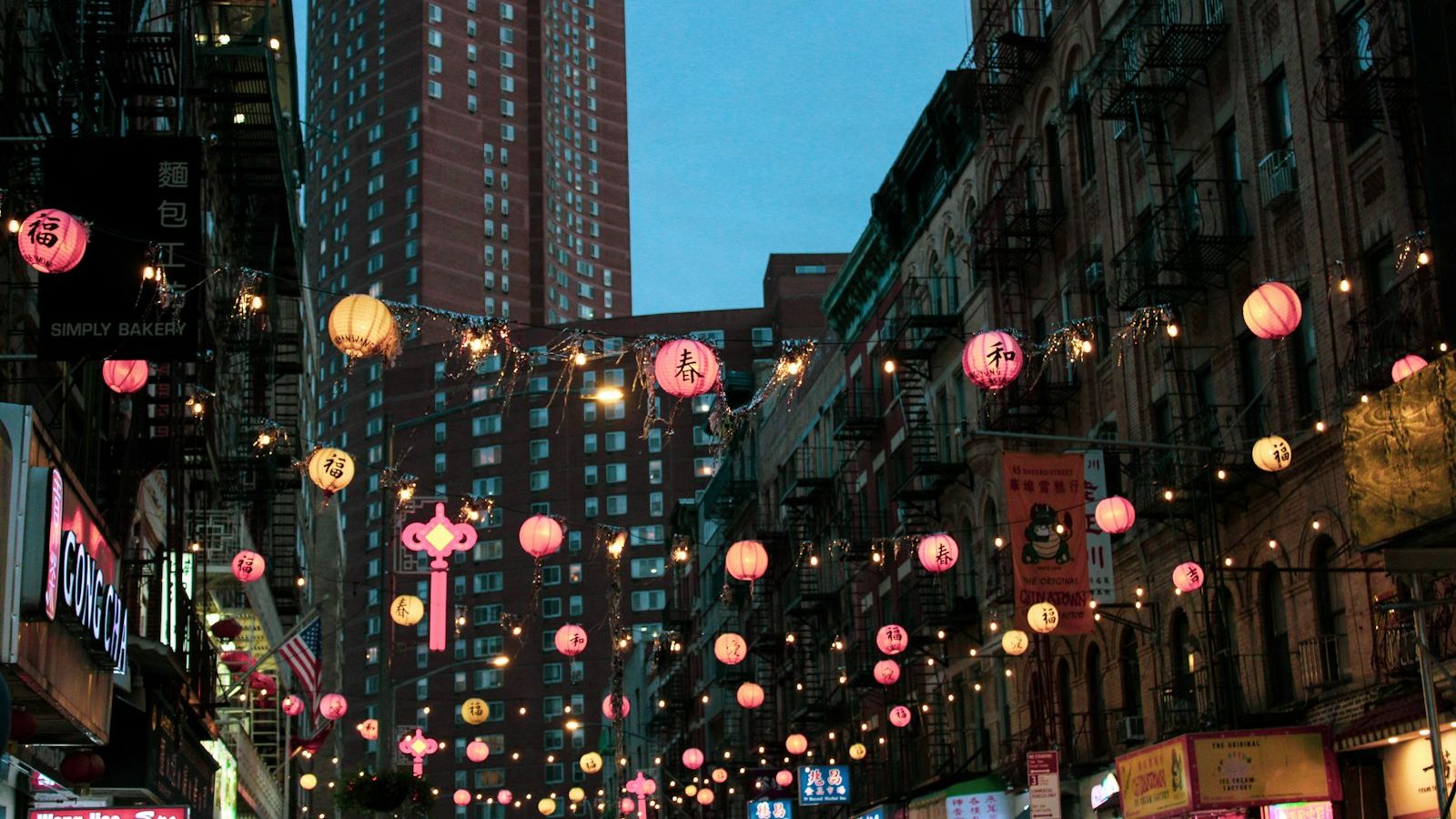 Pink lanterns hanging over Mott Street in Manhattan's Chinatown at dusk