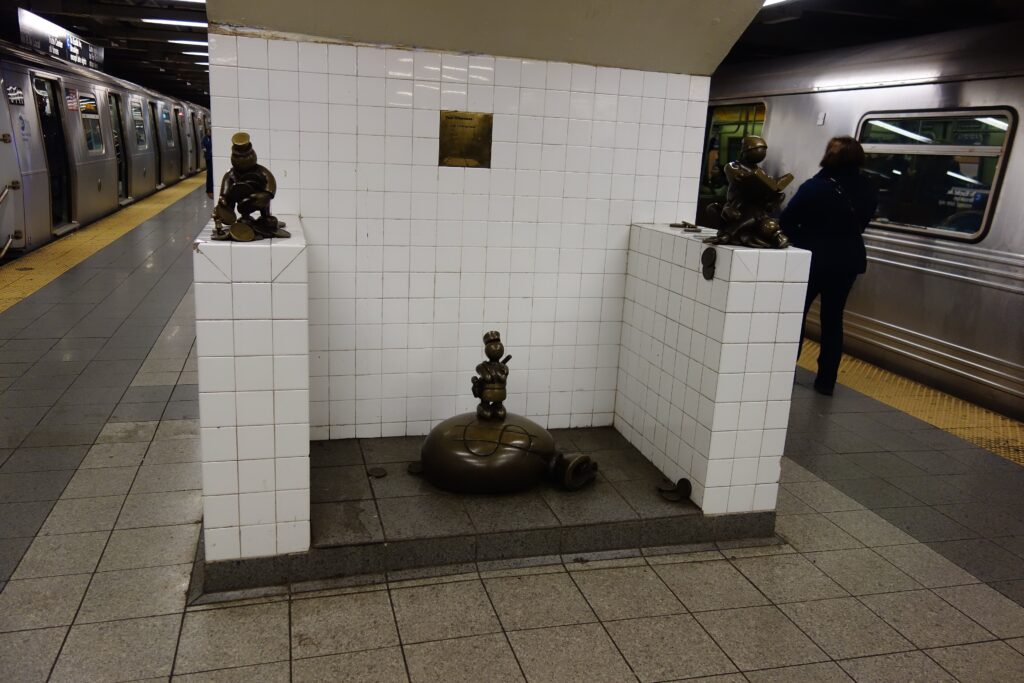Tom Otterness bronze figures from Life Underground on a tiled pillar at the 14th Street–Eighth Avenue subway station