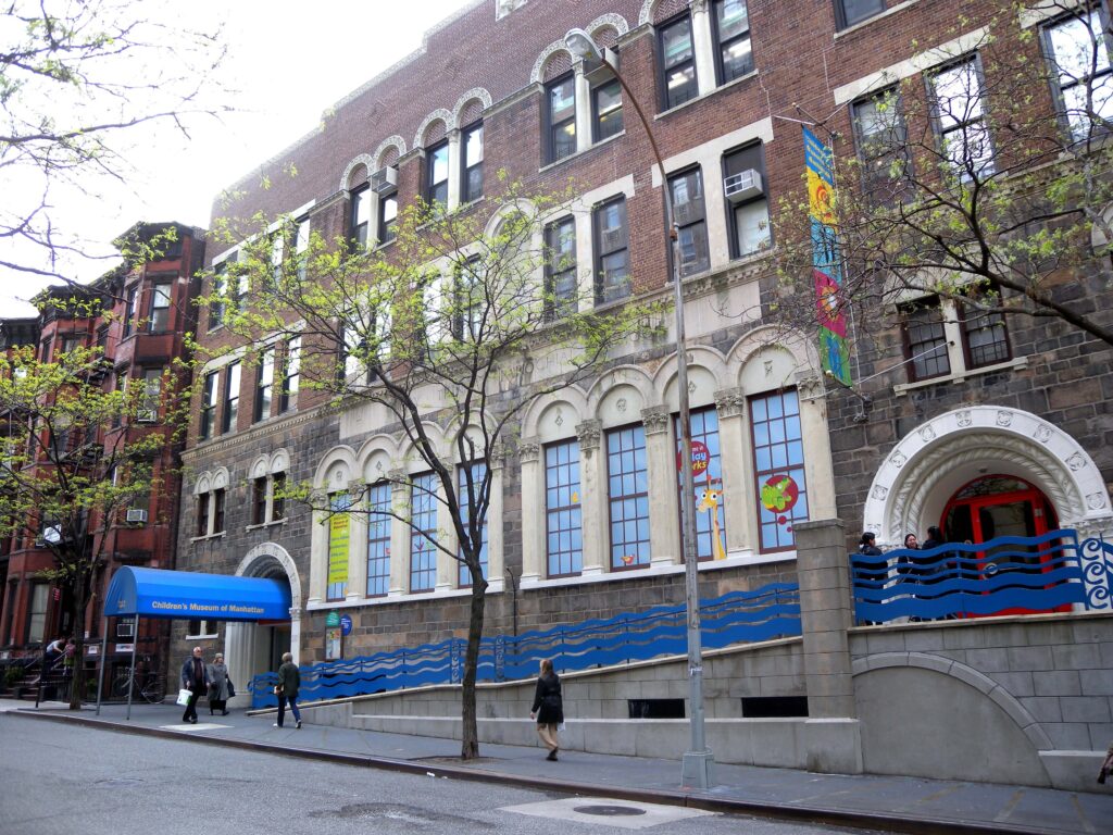 The brick and stone front of the Children’s Museum of Manhattan on West 83rd Street, with its blue awning