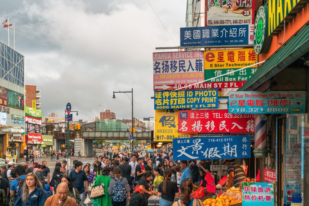 Crowds and Chinese-language shop signs on Main Street in Flushing, Queens