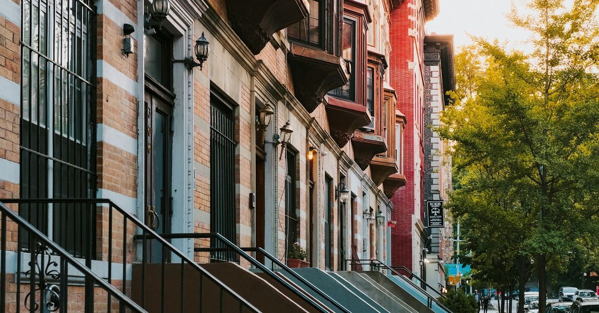 Harlem brownstone row houses with tree-lined street — the heart of Black America's cultural capital