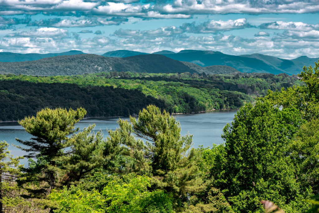 The Hudson River in upstate New York, with green woods in front and the Catskill Mountains behind