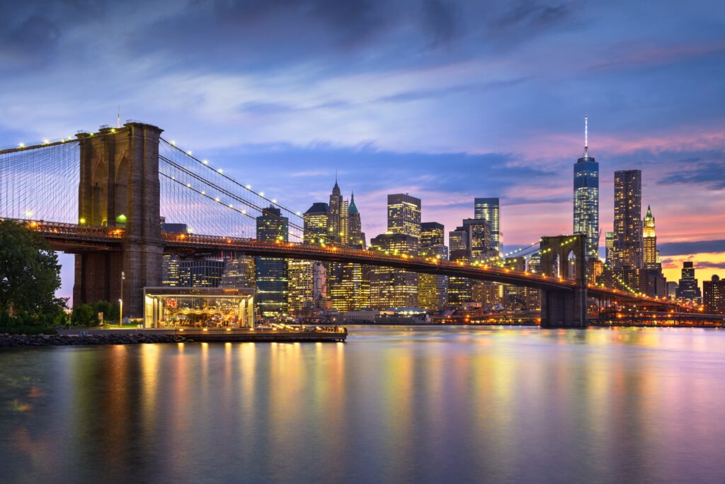Lower Manhattan and the Brooklyn Bridge at dusk across the East River