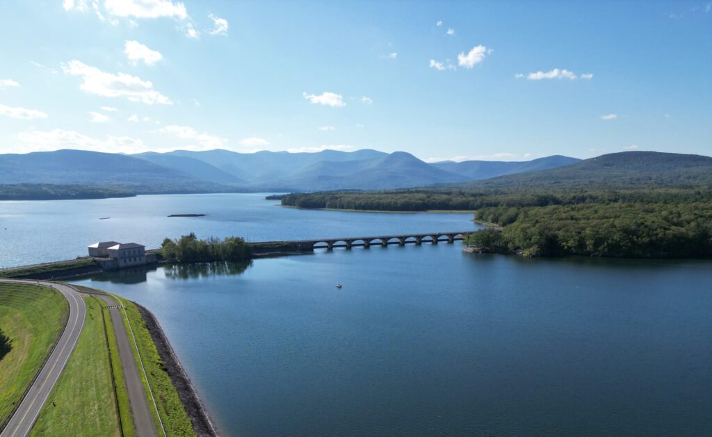 Aerial view of the Ashokan Reservoir and its arched bridge, with the Catskill Mountains behind, near Woodstock