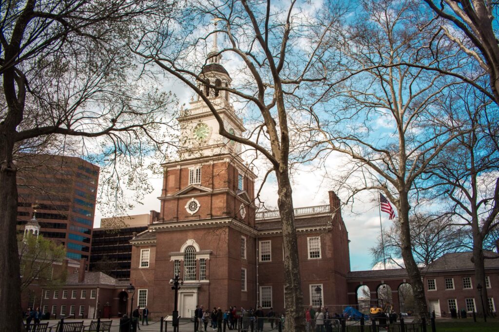 The red-brick tower of Independence Hall in Philadelphia seen through bare spring trees