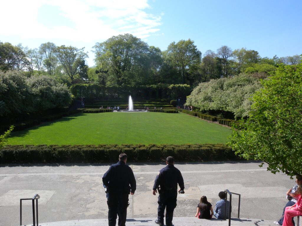 The central lawn of the Conservatory Garden in Central Park, with a fountain and a wisteria pergola at the far end