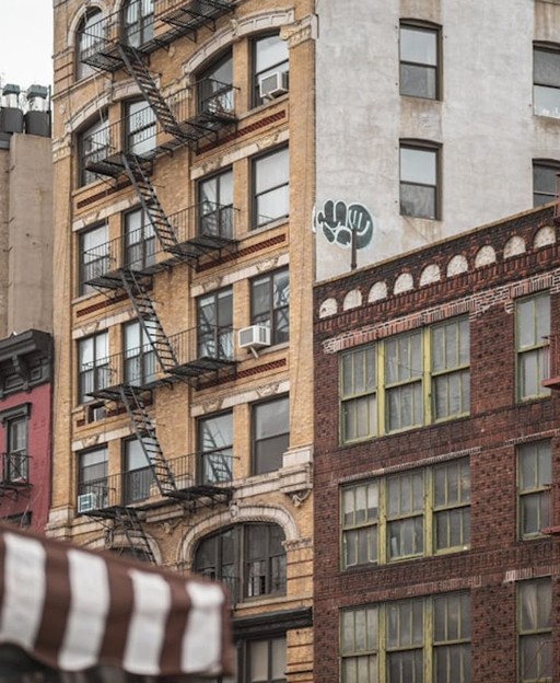 Classic tenement buildings in Manhattan with iron fire escapes — the style of housing that defined Five Points