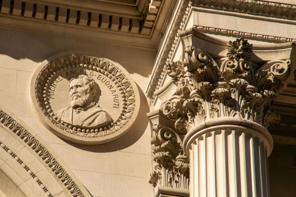 A carved Michelangelo medallion and a Corinthian column on the facade of the Metropolitan Museum of Art