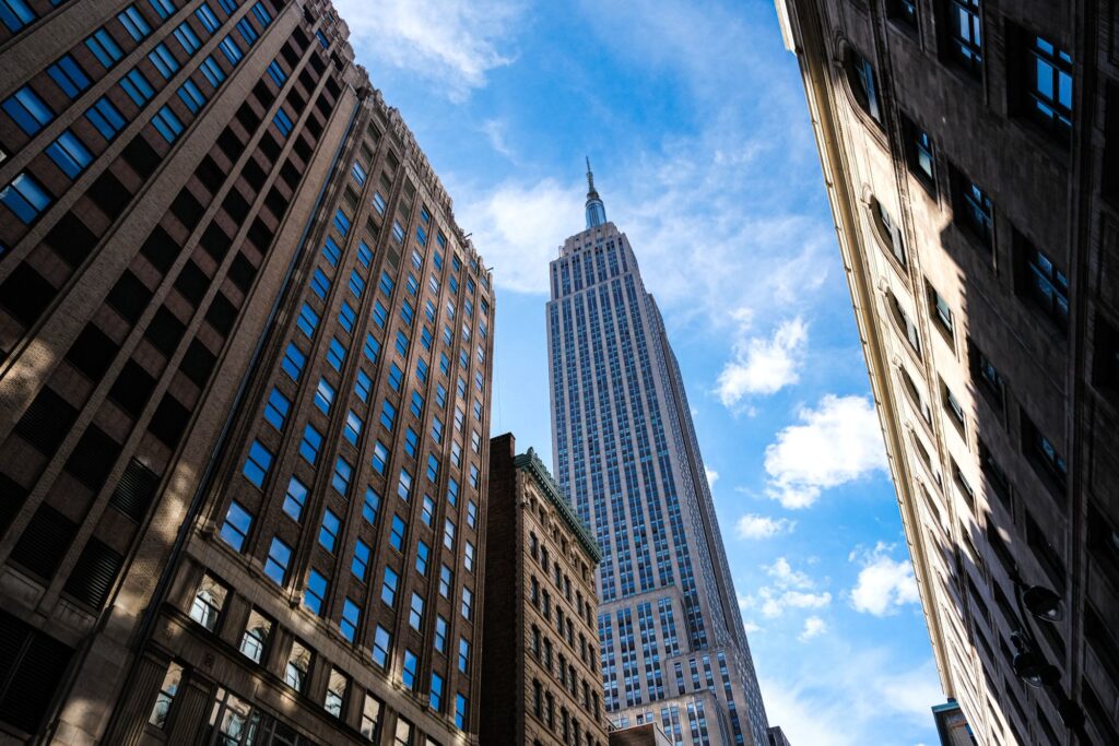 Looking up at the Empire State Building between Midtown office buildings on a sunny day