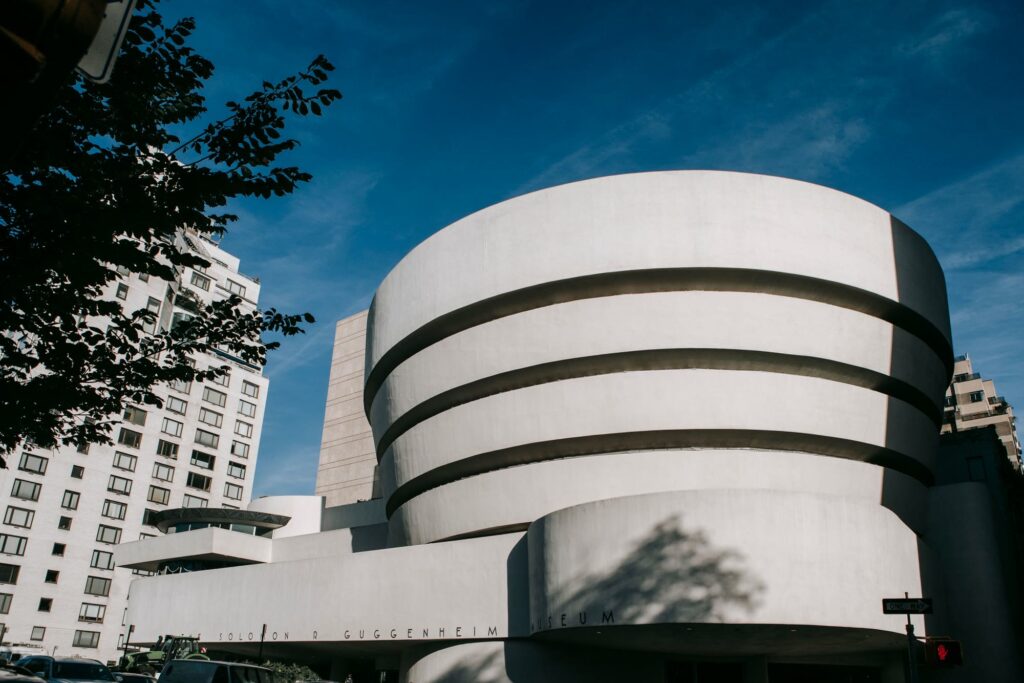 The white curved bands of the Guggenheim Museum on Fifth Avenue against a deep blue sky