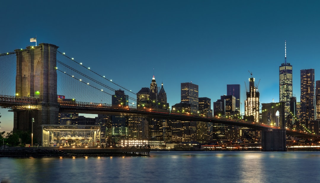 Brooklyn Bridge lit up at night with the Manhattan skyline in the background