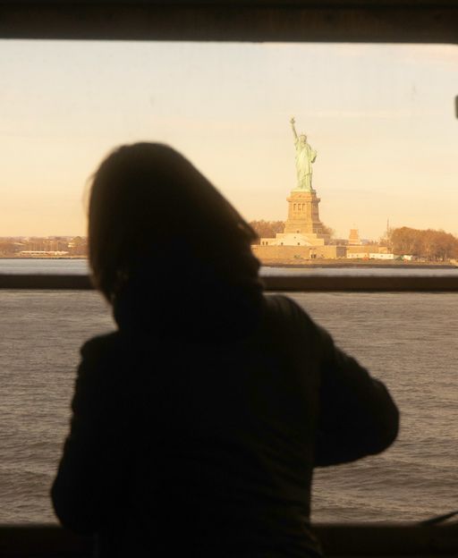 Tourist photographing the Statue of Liberty from the free Staten Island Ferry, one of the top things to do in Staten Island, New York