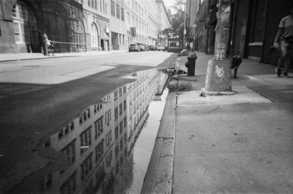 TriBeCa loft buildings reflected in a puddle on a Manhattan street