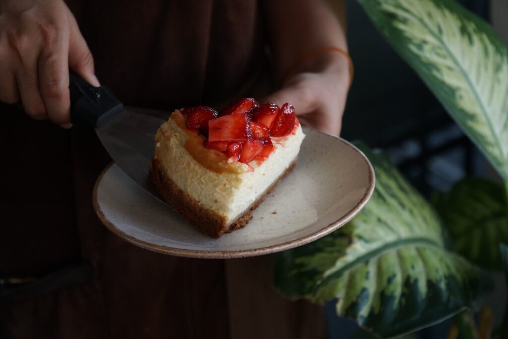 A slice of cheesecake with strawberry topping