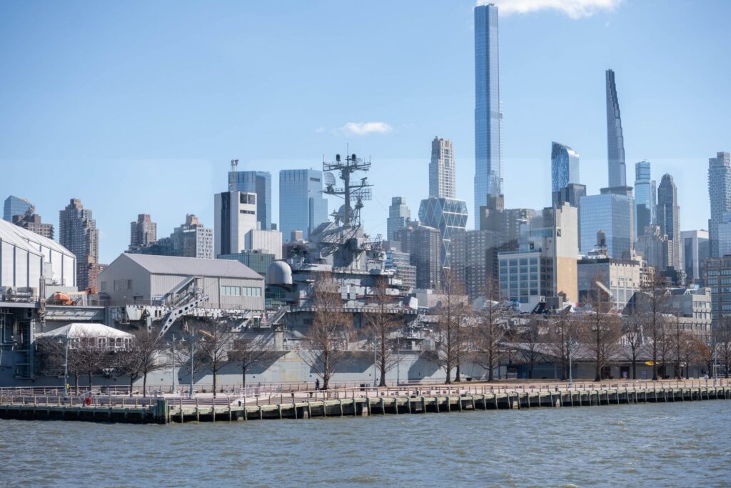 The aircraft carrier USS Intrepid moored at Pier 86 on the Hudson River, with Midtown towers behind