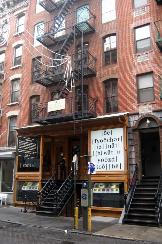 The red-brick Tenement Museum building at 97 Orchard Street, with its black fire escape and wooden storefront