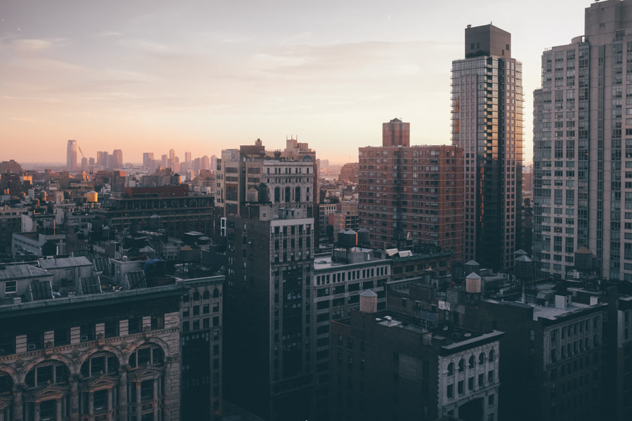 Sunset over the brick rooftops and water towers around Fifth Avenue, photographed from the 230 Fifth rooftop