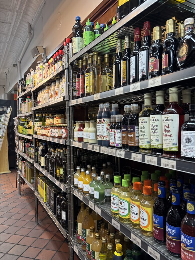 Metal shelves packed with bottles of vinegar, olive oil, glazes and sauces inside Sahadi's on Atlantic Avenue