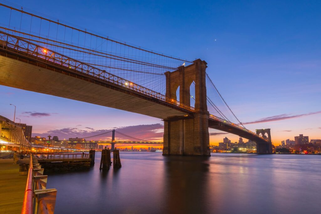 The Brooklyn Bridge at dawn from the Manhattan waterfront, with the Manhattan Bridge in the distance