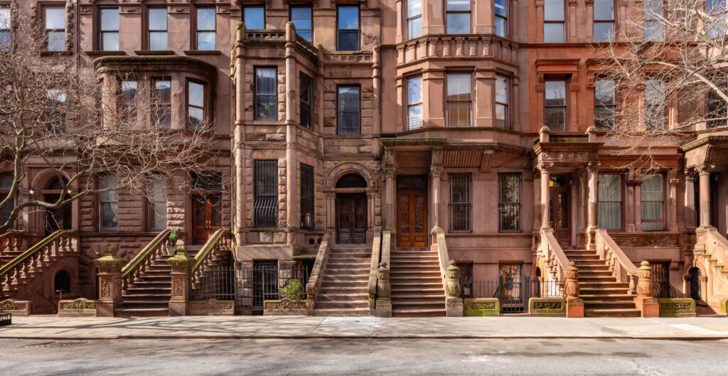 A row of brownstone townhouses with tall stoops in the Mount Morris Park Historic District, Harlem