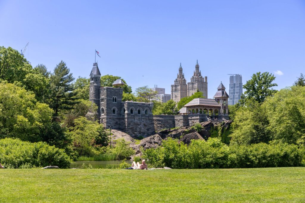 A sunbather on the lawn at the south end of the Great Lawn, looking across Turtle Pond to Belvedere Castle