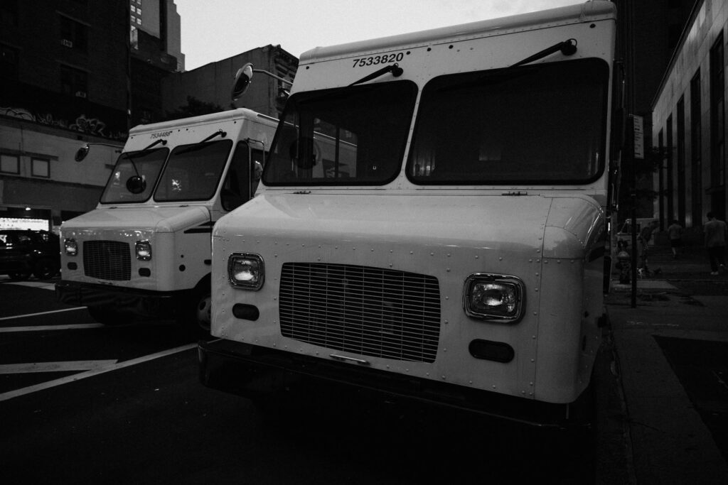 Two delivery vans parked at the curb on a New York City street