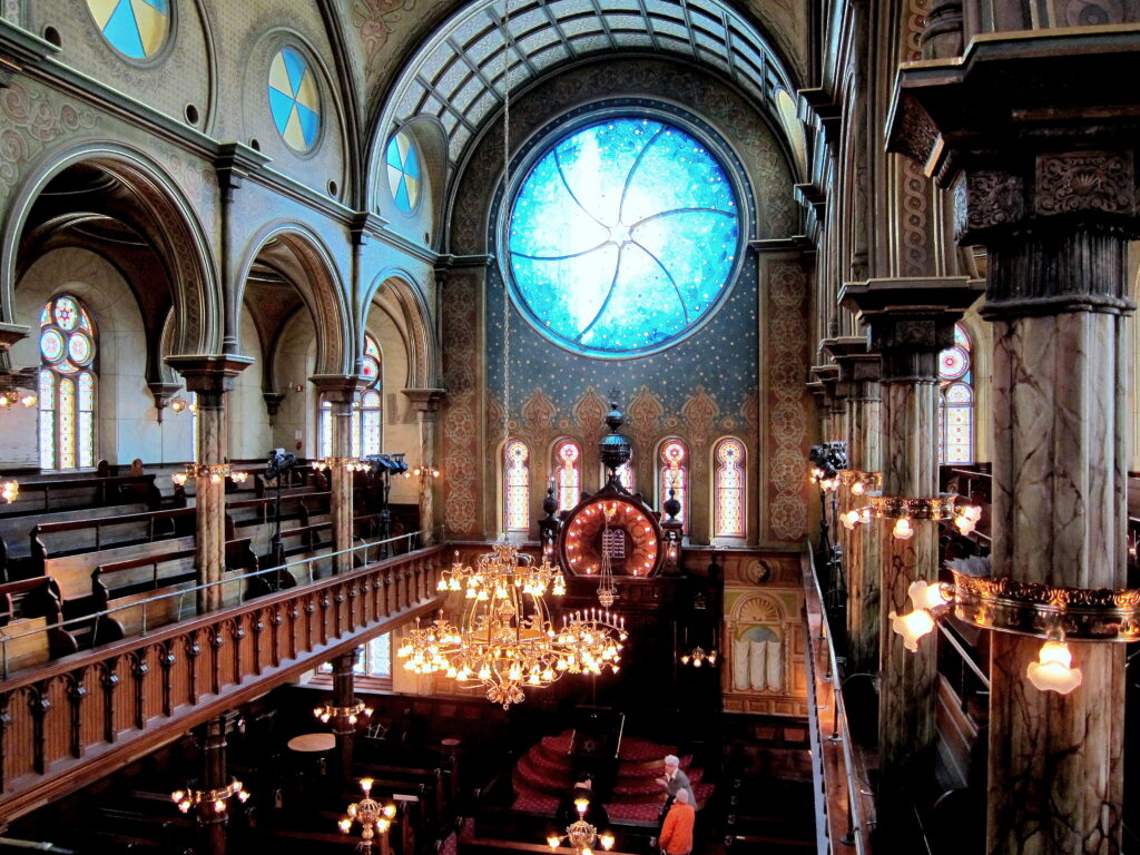 Sanctuary of the Eldridge Street Synagogue with its blue round window and chandelier