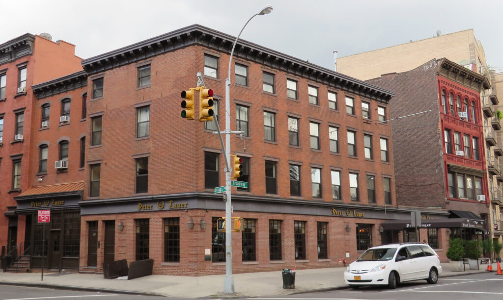 The brick corner building of Peter Luger Steak House at Broadway and Driggs Avenue