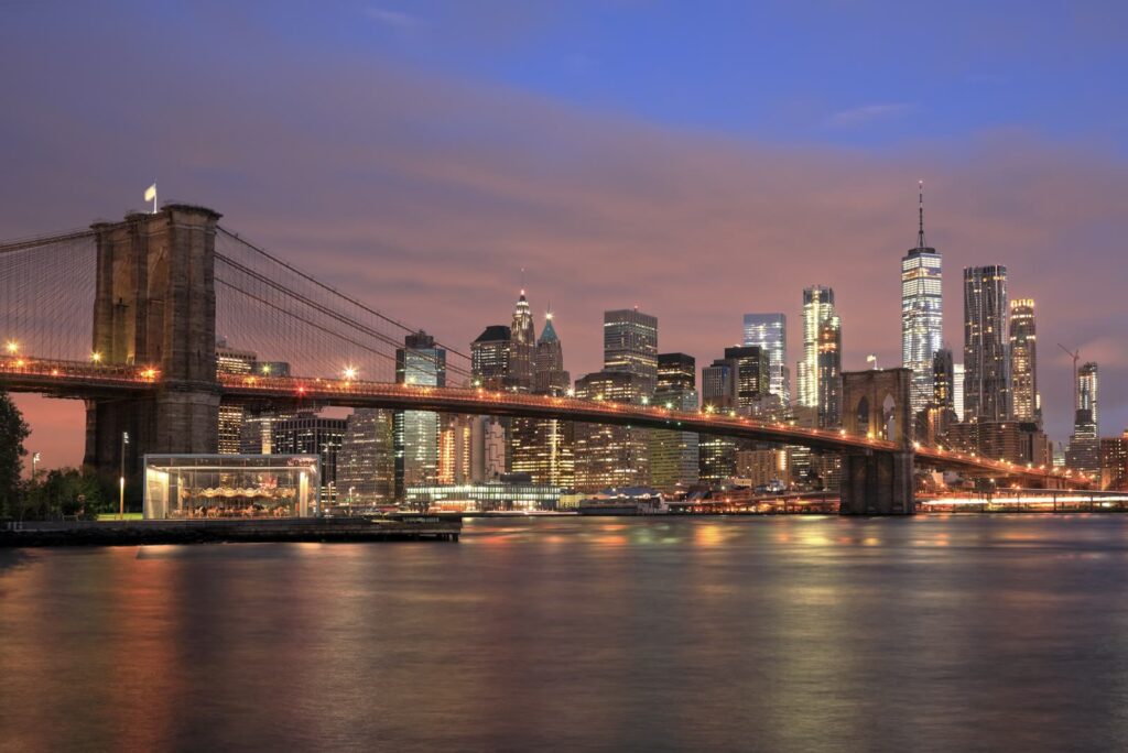 The Brooklyn Bridge and the Lower Manhattan skyline at dusk across the East River