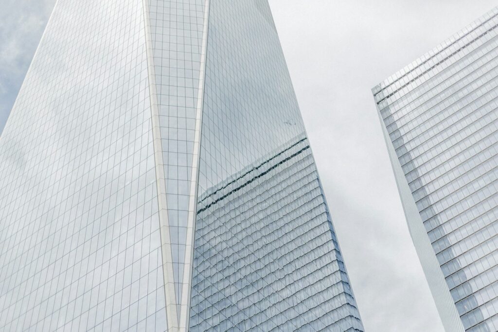 Looking up at the glass facade of One World Trade Center on a cloudy day